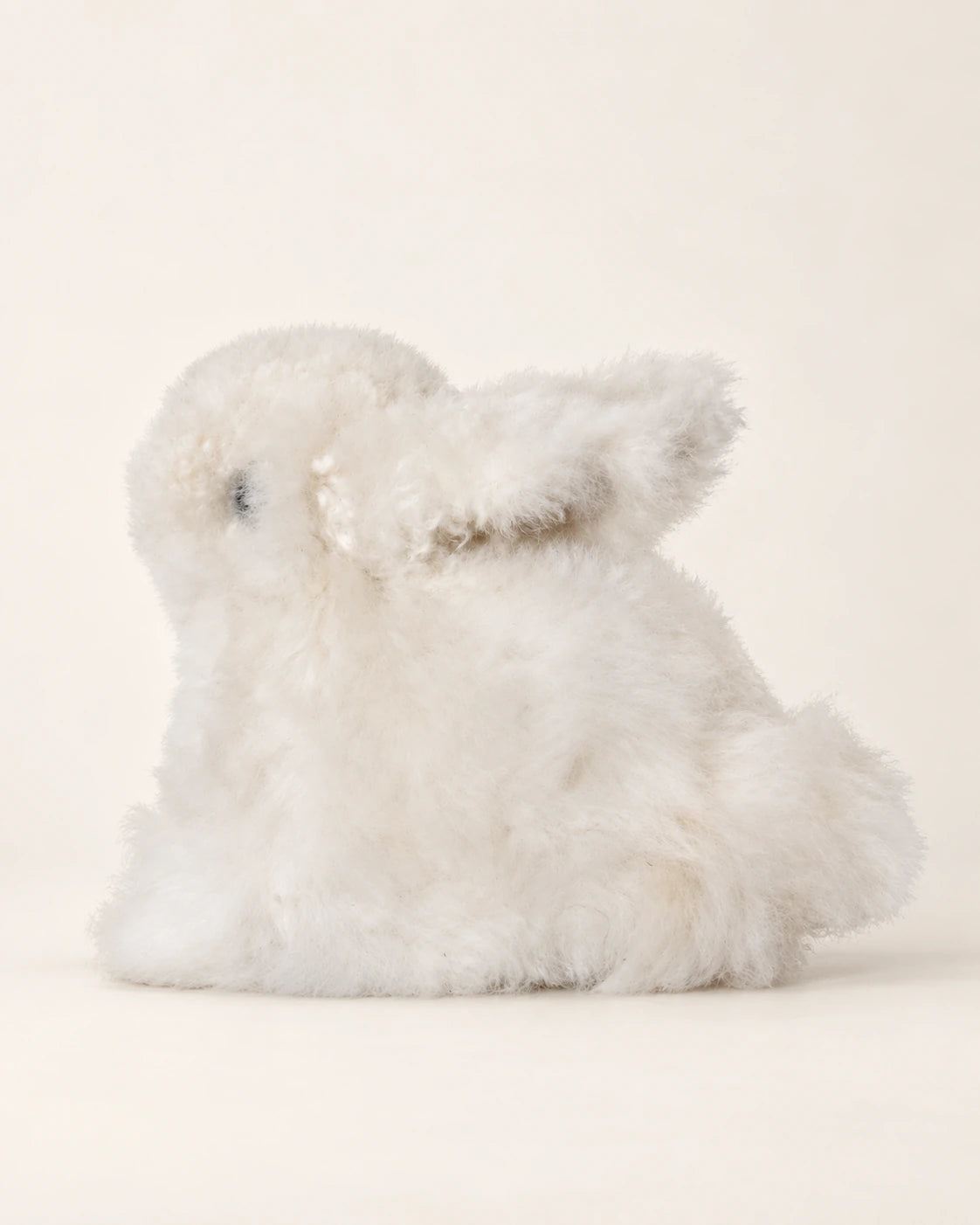 Peluche lapin blanche en laine d’alpaga, vue de profil montrant les longues oreilles et la petite queue.