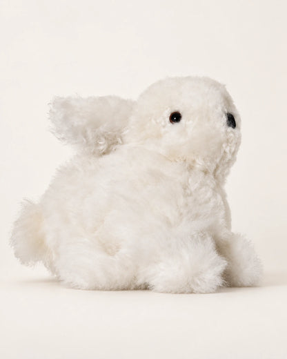 Peluche lapin blanche en laine d’alpaga de 15 cm, vue de trois quarts sur fond crème.