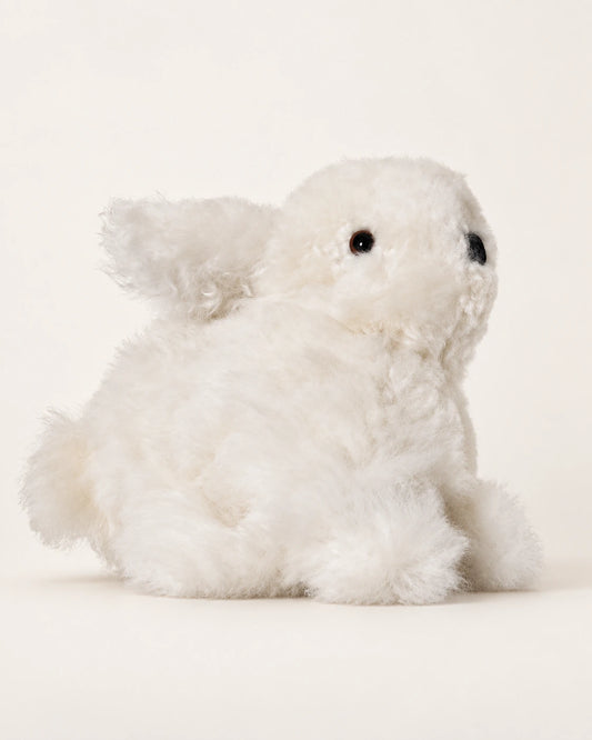 Peluche lapin blanche en laine d’alpaga de 15 cm, vue de trois quarts sur fond crème.